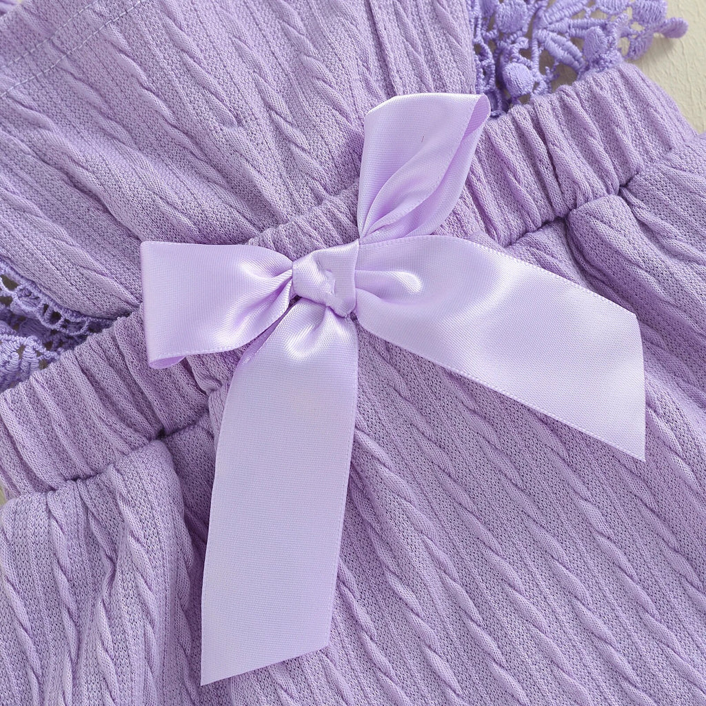 this is a photo of a purple bow on a purple baby romper